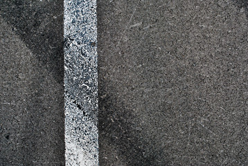 Fototapeta premium Asphalt texture with white line and tire marks . Top view