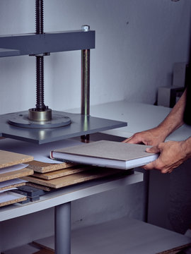 Faceless employee using pressing machine in printing office