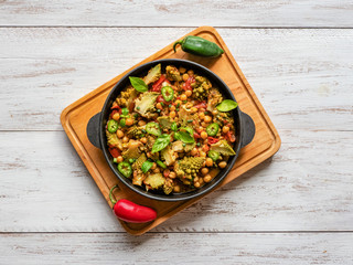 Nutty roasted romanesco curry in a iron frying pan. Top view. 