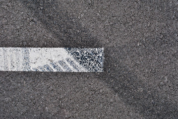 Fototapeta premium Asphalt texture with white line and tire marks . Top view