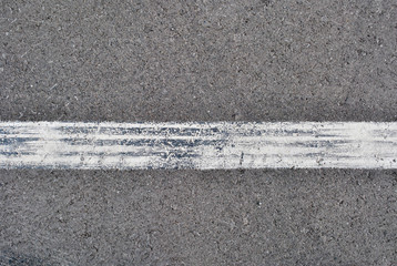 Fototapeta premium Asphalt texture with white line and tire marks . Top view
