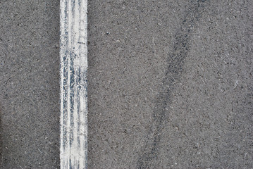 Fototapeta premium Asphalt texture with white line and tire marks . Top view