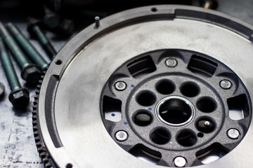 dual-mass flywheel with fastener parts in the background