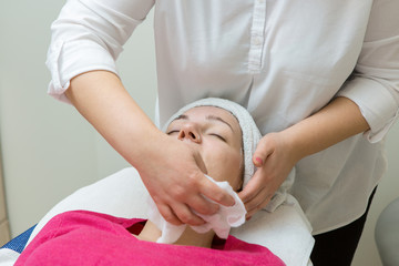 Obraz premium Face skin care. Beautician applying beauty oil mask on face using brush In spa salon 