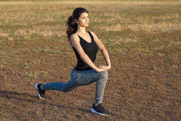 A young slim athletic girl in sportswear with snakeskin prints performs a set of exercises. Fitness...