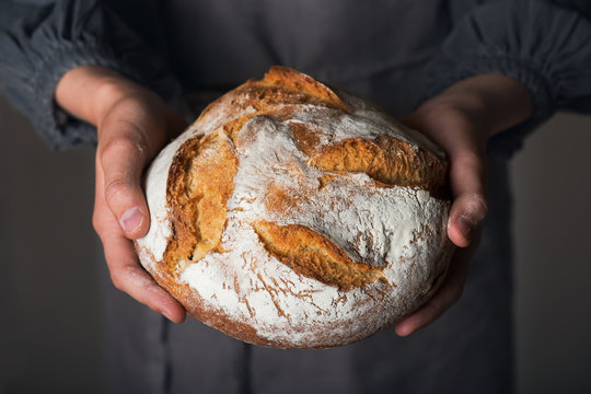 Female hands holding homemade fresh baked bread. Gluten free, healthy diet concept.
