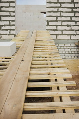 Enter a wooden gangway intol building under construction