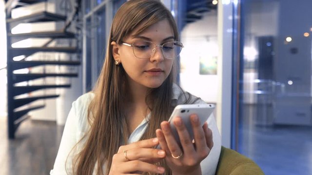 Business woman using smartphone dating app looking swiping on screen, happy young girl holding phone enjoy watching media in mobile online application on cellphone
