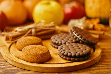 Cookies with pumpkins and apples on the table. Cookies and autumn decor. Pumpkins and apples in the background.