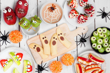 Healthy Halloween fruit snacks. Selection of fun, spooky treats. Top view table scene over a white...