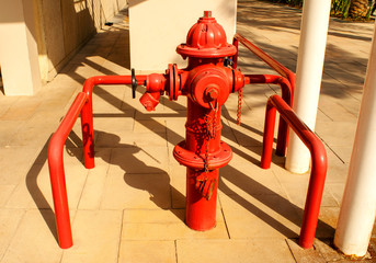 Red pillar-type fire hydrant for emergency fire access in a street. 