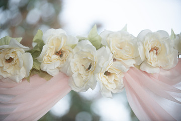 White magnolia flowers and pink valence decorated wedding arch