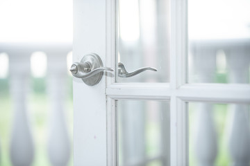 White vintage door wedding arch with silver handles on white column balcony
