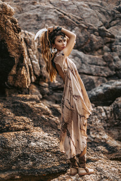 beautiful young woman in stylish boho dress. boho style model posing outdoors at sunset