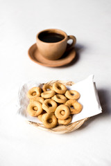 Rosquillas served in a handmade palm tray accompanied by a cup of coffee. Nicaraguan breakfast. White background without people.
