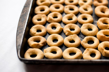 Rosquillas de queso / cuajada on a black tray. White background no people.