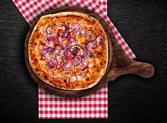 Original Italian pizza Peperoni and Onions on the black stone plate. Set for menu or banner.  Concept Pizza delivery service to home