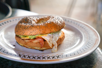 Bagel with bacon and eggs on a plate