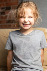 Young girl posing on light brown chair