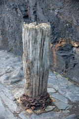 Rusted chains on old wooden post