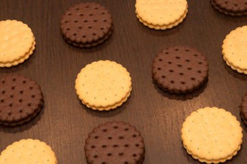 white and dark cookies on a brown wood table