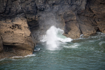 Large waves blowing through a hole in rocks in Boscastle