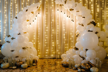Decorated arch for wedding ceremony. White balloons, candles, autumn leaves and small pumpkins....