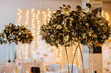 Dry golden bouquet leaves on the table on light background. Gold wedding reception.  Autumn style....