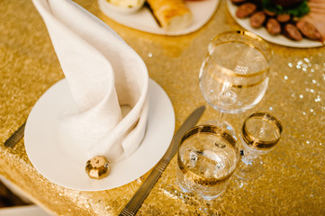 Luxury elegant table setting dinner in a restaurant. Selective focus on glasses. Banquet table in the restaurant, the preparation before the banquet. Gold wedding reception with small pumpkin. Autumn.