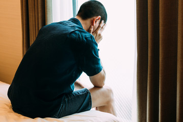 PTSD Mental health concept - Depressed Man with Problems sitting alone head in hands on the bed and Crying. Psychological trauma, Erectile, Frustration, Miserable, .Despair, Men health concept. - obrazy, fototapety, plakaty
