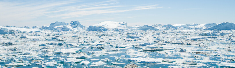Global Warming and Climate Change - Icebergs and ice from melting glacier in icefjord in Ilulissat, Greenland. Aerial photo of arctic nature ice landscape. Unesco World Heritage Site. Panoramic banner © Maridav