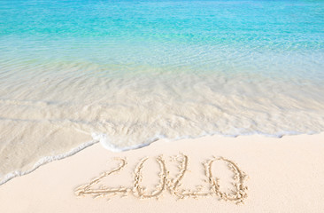 Fototapeta na wymiar Happy New Year 2020 on the sand and beach