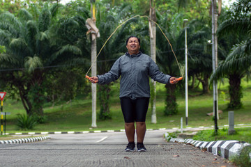 fat obese man doing exercises with jumping rope overweight guy training workout weight loss