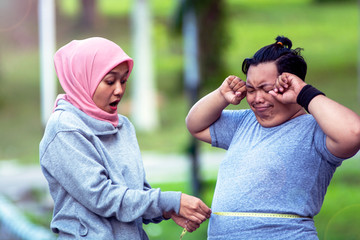 Two people, muslim woman and fat man, proportional and over weight, muslim woman with proportional...