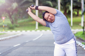 Asian young men with obesity trying to lose weight with barbell exercises and feel not strong