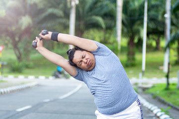 Asian young men with obesity trying to lose weight with barbell exercises and feel not strong