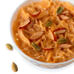 Vermicelli dessert, popular sweet dish know a kheer made with milk and garnish with dry fruits isolated on white background, served in bowl. Selective focus. Top view.