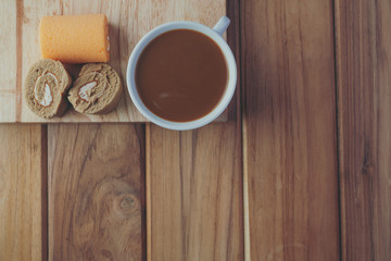Fototapeta na wymiar Coffee and bread placed on brown wood floors.