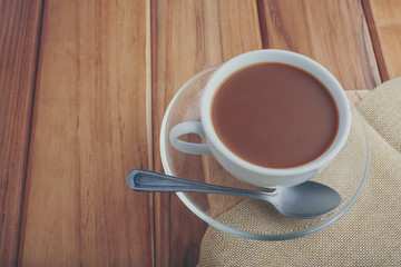 Coffee set placed on the fabric and brown wood floor.