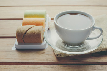 Coffee and bread placed on brown wood floors.