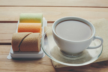 Coffee and bread placed on brown wood floors.