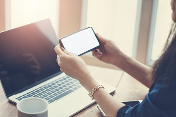 Woman using smart phone while working in the coffeeshop. Modern and smart lifestyle with online mobile technology.