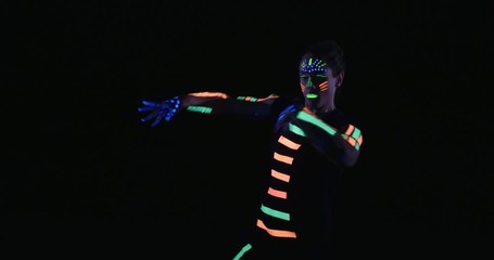 Studio, slow motion, male neon-clad dancer dancing in blacklight, London