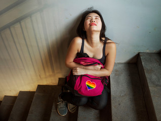 respect for homosexual and anti sexual discrimination campaign. Young beautiful depressed and scared Asian student woman with gay flag on her backpack