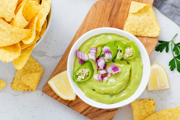 Bowl of fresh guacamole sauce  with corn chips nachos.