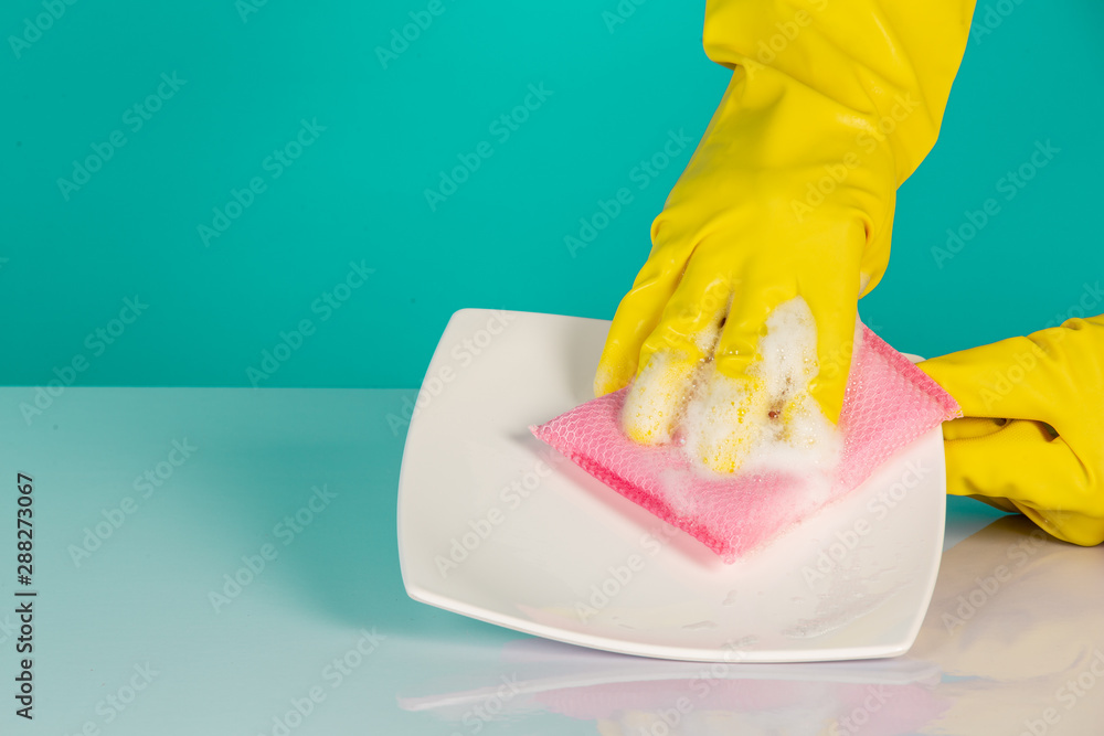 Wall mural The concept of dishwasher wearing yellow gloves on a blue background.