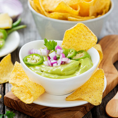 Bowl of fresh guacamole sauce  with corn chips nachos.
