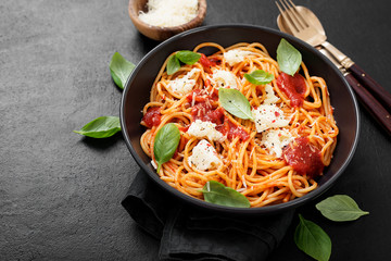 Spaghetti with  tomato sauce, parmesan and mozzarella cheese decorated with basil.