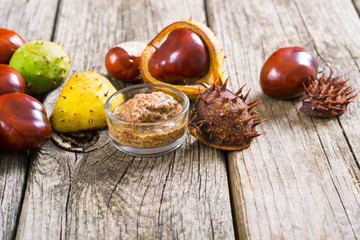 medicine and cosmetics raw ingredient: alcohol tincture from horse chestnuts on old wood table...