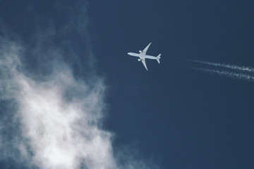 Fototapeta na wymiar Airplane In Blue Sky With Plane Trails